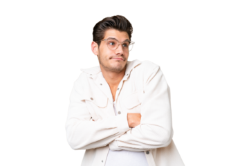 Young handsome caucasian man over isolated background making doubts gesture while lifting the shoulders