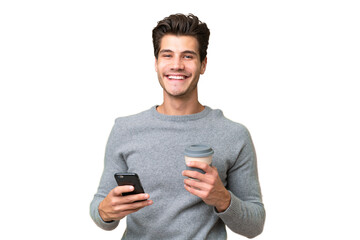 Young handsome caucasian man over isolated background holding coffee to take away and a mobile