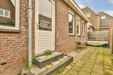 an outside view of a house with brick walls and white shutters on the front door there is a green lawn