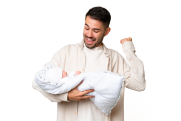 Young caucasian father with her newborn baby over isolated background celebrating a victory