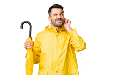 Young caucasian man with rainproof coat and umbrella over isolated background frustrated and covering ears