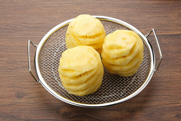 Fresh and Ripe Peeled Pineapple on a cooling rack
