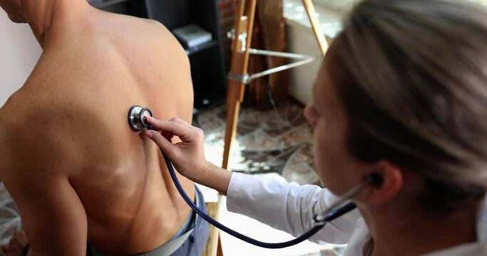 Woman doctor therapist cardiologist checks patient with stethoscope in hospital. Lung auscultation and breath sounds and bronchitis with pneumonia