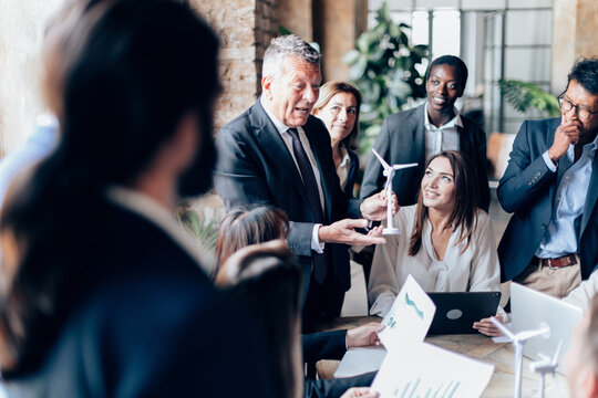 senior manager and ceo explaining wind turbine project to younger colleagues