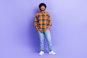 Fototapeta premium Full size portrait of positive cheerful young person put hands pockets posing isolated on purple color background