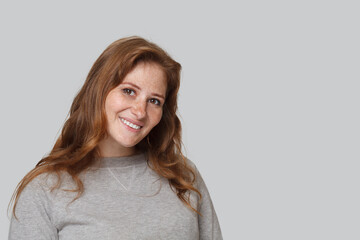 Redhead model woman smiling on white background, studio portrait