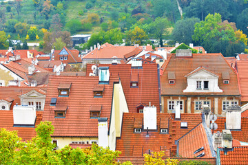 View of the old white houses with a red tiled roof. Ancient buildings in the village with trees. Cityscape. Prague, Czech Republic, October 2022.
