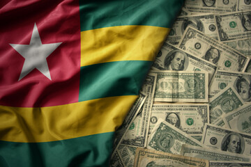 colorful waving national flag of togo on a american dollar money background. finance concept