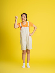 cute asian girl posing on a yellow background