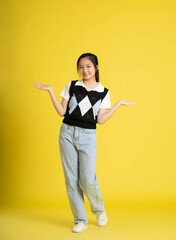 fullbody image of asian girl standing and posing  on yellow background