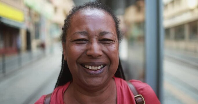 Senior african woman smiling in front of camera at tram station