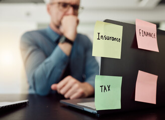 Insurance, tax and finance on sticky notes with a thinking business man in an office at a desk...
