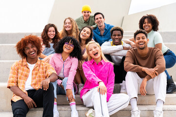 Happy playful multiethnic group of young friends bonding outdoors - Multiracial millennials...