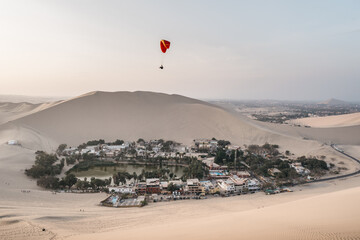 Paragliding during the Sunset in the Huacachina oasis in Ica, Peru - 628491988