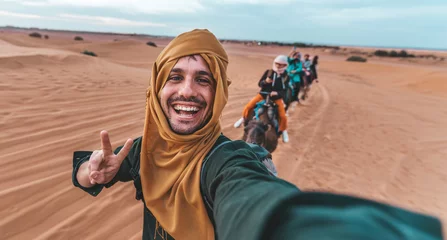 Photo sur Plexiglas Dubai Happy tourist having fun enjoying group camel ride tour in the desert - Travel, life style, vacation activities and adventure concept