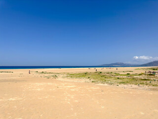 Weitläufiger breiter Sandstrand und Dünen in Tarifa an einem schönen Sommertag und blauem...