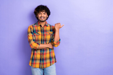 Photo of young man promo good news reporter wear checkered shirt pointing finger mockup useful tips isolated on violet color background