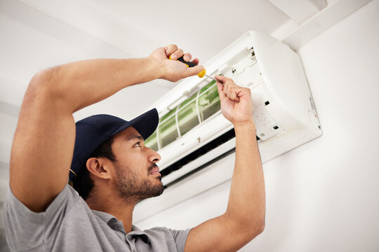 Air conditioner, man and electrical machine repair with person in a home with ac box. Maintenance, screwdriver and system control for installation, inspection of aircon fix in house with contractor