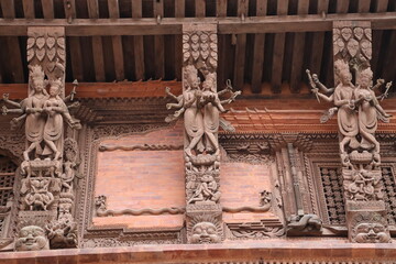 Wooden reapers with elegant carvings of god and and goddess placed in an angles to support the slopped roof of the building in kathmandu, nepal, detailed architecture carving which looks beautiful