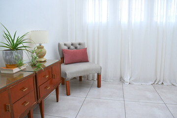 interior view of a large window with white curtains and different furniture.