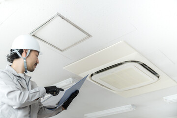 業務用エアコンを確認や修理をする作業員のイメージ