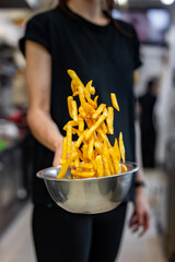 woman chef preparing french fries in restaurant kitchen