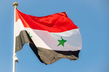Naklejka na ściany i meble Syria flag in the blue sky. horizontal panoramic banner. Close-up of waving Syrian flag. Great photo for news illustrations.