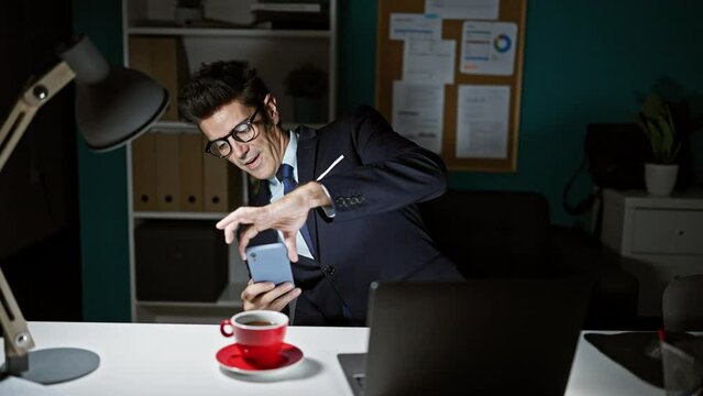 Young hispanic man business worker make photo to coffee by smartphone at the office