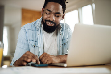 Happy black man calculating home finances