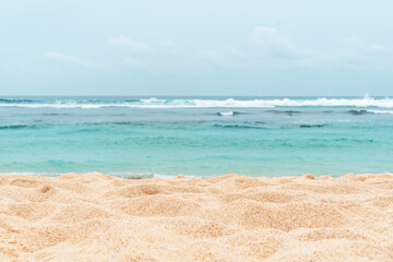 Empty sandy beach in the background with a blurry summer sea.