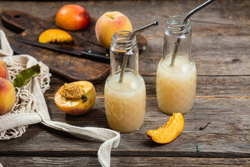Peach juice in bottle on wooden background
