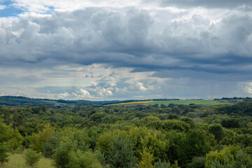 Landscape image of countryside of Ukraine. Cloudy sky, grassy fields and rolling hills rural scenery