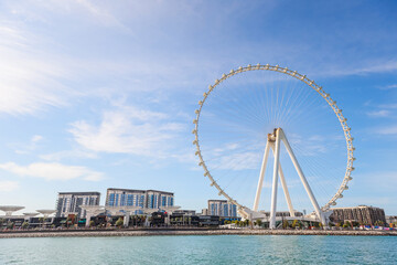 Dubai ferris wheel and city skyline from Jumeirah Beach.