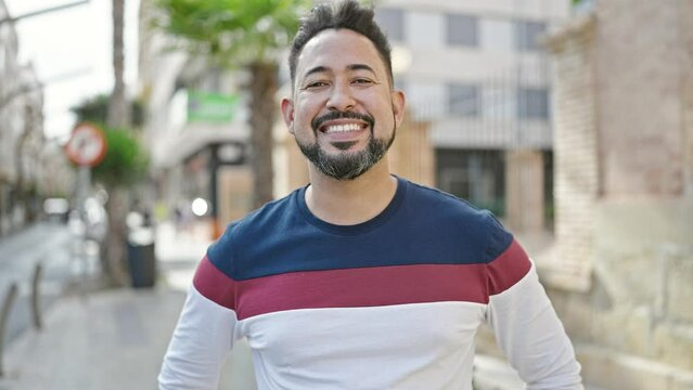 Young latin man smiling confident standing at street