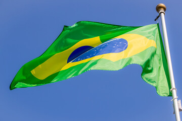 Brazil flag in the blue sky. horizontal panoramic banner. Close-up of waving the flag of Brazil. Great photo for news illustrations.