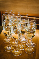 Champagne. Many glass of white wine. Glasses of champagne on table bar. Buffet. Celebration of birthday, baptism, wedding, corporate party. Catering service. Serves glasses of sparkling wine. Closeup