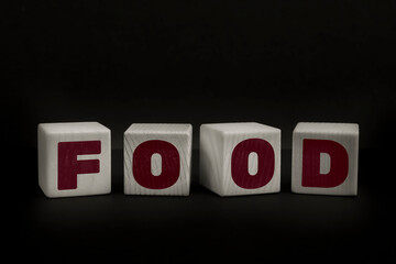 Obraz premium Word FOOD written with wooden cubes. Studio shot of some arranged wooden blocks with a testual message about disinformation.