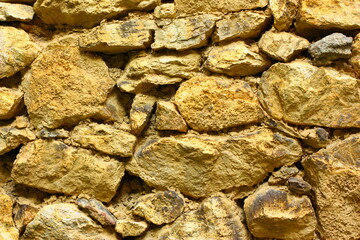 A wall of large and small brown stones. High quality photo