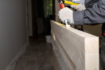 Preparing a place for the lock in the interior door. The worker's hands use a chisel to remove the wood from the door.