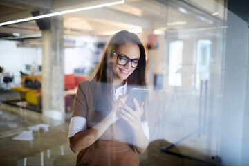 Young woman using a smart phone while working in a startup company office