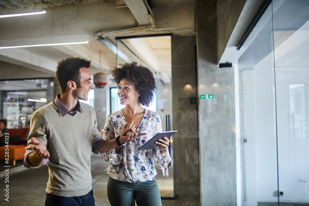 Wall mural two young people using a tablet together while working in a startup company office