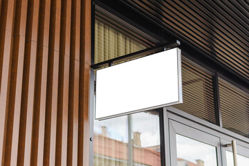 Blank white business signboard mockup. Empty illuminated shop lightbox template mounted on wall. Mock up of illuminated blank signboard. Place for text, outdoor advertising, banner.