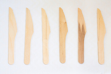 Disposable eco friendly wooden knifes on white background. Eco friendly disposable wooden cutlery on white background.