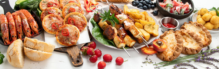 Family dinner or lunch. Many dishes on the table. Summer.