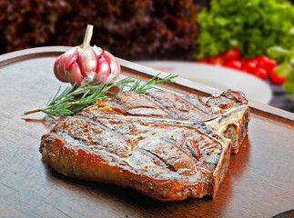 T bone steak with trimmings, potato, salad, orange juice, bread