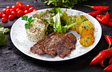 Beef steak with potatoes and rice in isolated white background