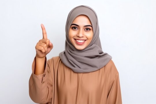 A Woman Wearing A Head Scarf Pointing Up