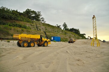 large truck dumb earth moving on the desert beside cliffs sea walls