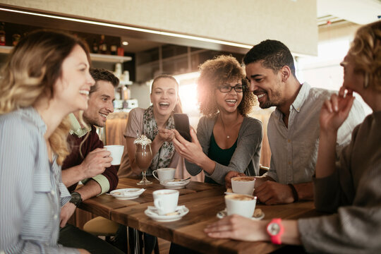 Diverse group of young people talking and having a coffee at a cafe
