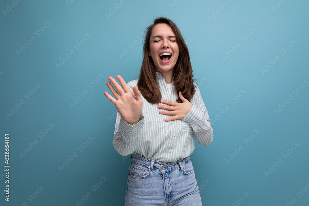 Poster pretty young brunette woman in shirt on studio background